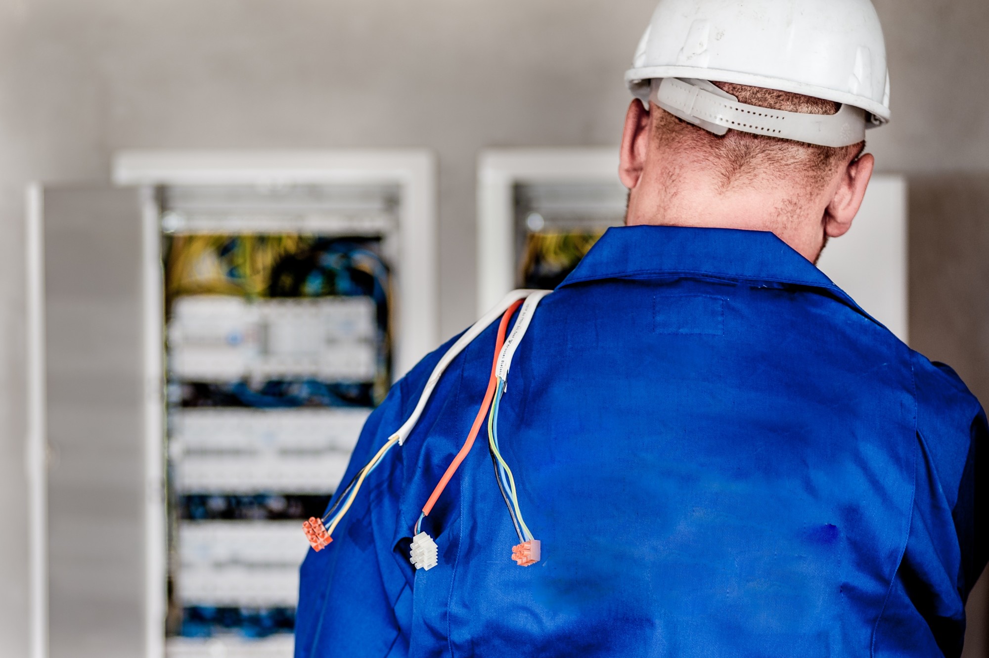 A person doing electrical work in a blue shirt